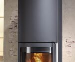 The image shows a stylish fireplace insert with a focus on the details. The stove impresses with its clean, modern lines in an elegant dark gray. The lower part of the image shows the glowing fire, which creates a warm and inviting atmosphere. This fireplace insert fits perfectly into contemporary living spaces and offers both functionality and an attractive design.