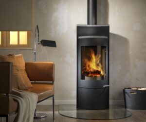 The alt text for the image could read: "Modern black wood-burning stove, model Vega III XL, in a cozy living room. The wood-burning stove radiates a cozy warmth and invites you to linger. The contemporary design blends elegantly into the interior décor. Perfect for a stylish and efficient heat source."