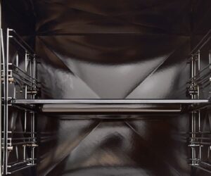 The alt text for the image could read as follows: "Close-up of the interior of a wood-burning stove. The smooth, shiny black interior surface shows the robust design of the wood-burning stove, ideal for even heat distribution. Perfect for efficient heating and comfortable coziness."