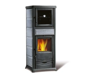 The picture shows an elegant wood-burning stove called "Rossella Plus Forno" with a natural stone cladding. This wood-burning stove combines modern design with functional heat radiation. The stove has an integrated baking compartment located above the fire chamber. The visible flame gives the room a cozy atmosphere and at the same time offers the possibility to prepare food. The natural stone complements the stylish appearance and stores heat efficiently. Perfect for lovers of wood-burning stoves who value design as much as functionality.