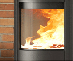 De afbeelding toont de glazen ruit van een elegante open haard, waardoor het laaiende vuur levendig te zien is. De vlammen dansen achter de heldere ruit, wat een warme en uitnodigende sfeer creëert. Dit fragment benadrukt de kwaliteit en transparantie van de ruit, terwijl het indrukwekkende effect van het vuur in een moderne houtkachel wordt getoond. Perfect voor elke stijlvolle woonkamer.