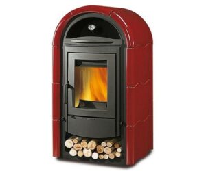 The picture shows an elegant wood-burning stove in Bordeaux. The stove has a curved top and is equipped with a large viewing window that allows you to see the flickering fire. Below the combustion chamber is a practical wood compartment filled with logs. The wood-burning stove impresses with its modern design and intense color, which gives it an elegant look. Ideal for bringing both warmth and style to any room.