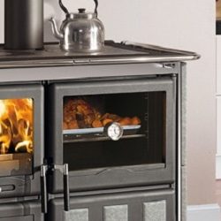 The image shows a section of a wood-burning stove that specifically highlights the baking compartment. On the left-hand side, you can see the flames in the stove, and on the right-hand side, the baking compartment where food can be cooked. The modern, elegant surface of the stove gives the room a stylish look. Perfect for anyone looking for a multifunctional wood-burning stove that not only provides heat but also serves as a baking oven.